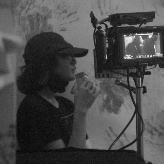 Jew Nuas behind the camera monitor on set